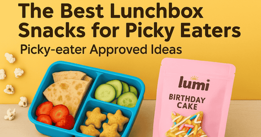 Lunchbox with pita wedges, cucumber slices, strawberries, popcorn, and Lumi Bites Birthday Cake snack stars on a yellow background for picky eaters.